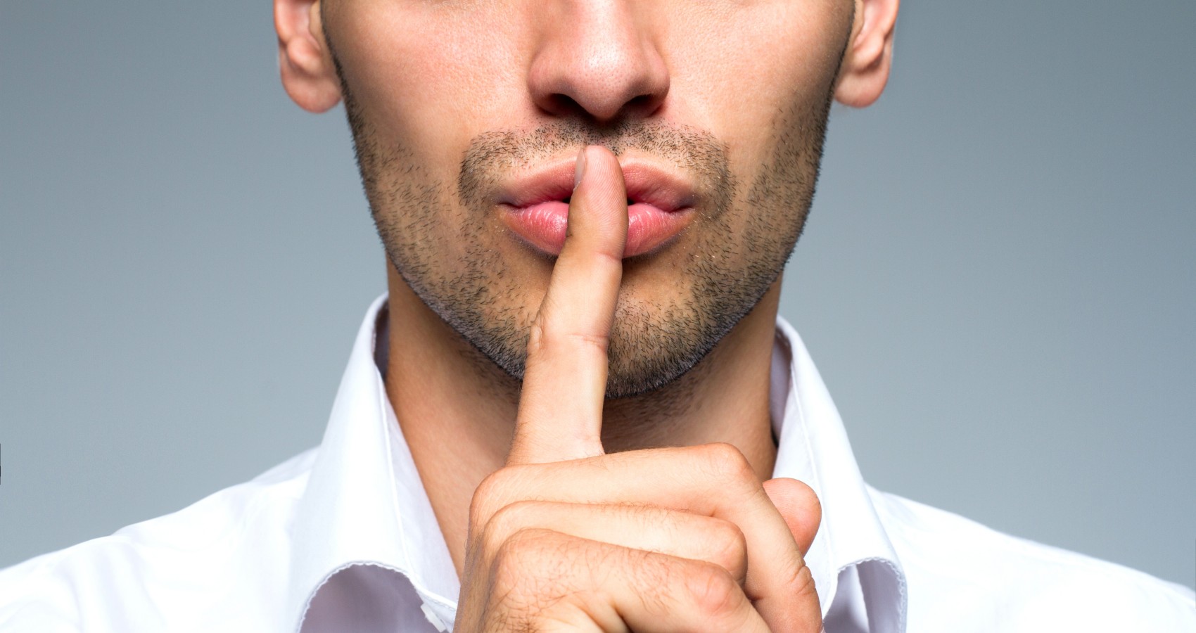 Businessman silent quiet gesture with finger