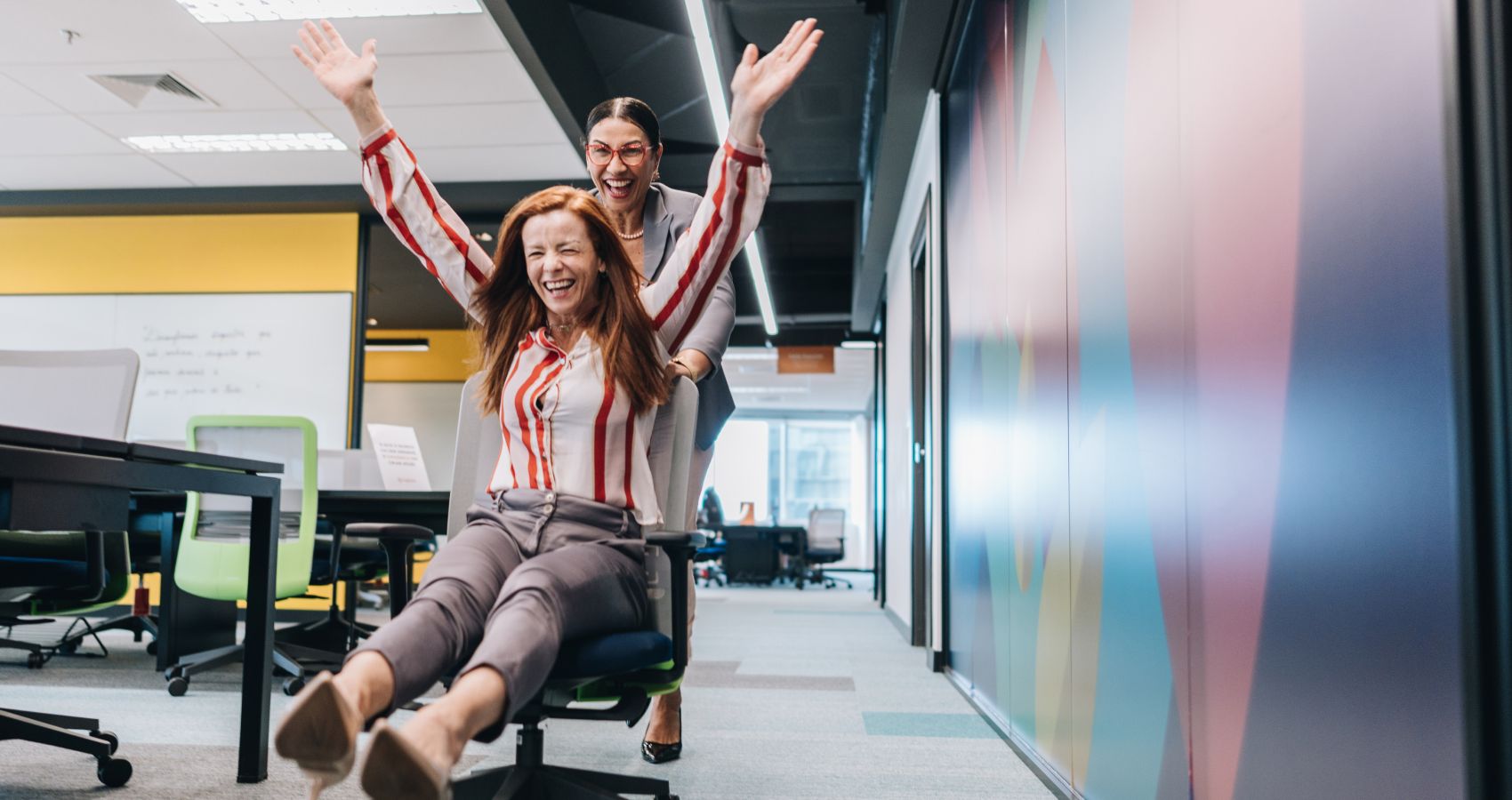 Businesswomen doing a chair race in the office